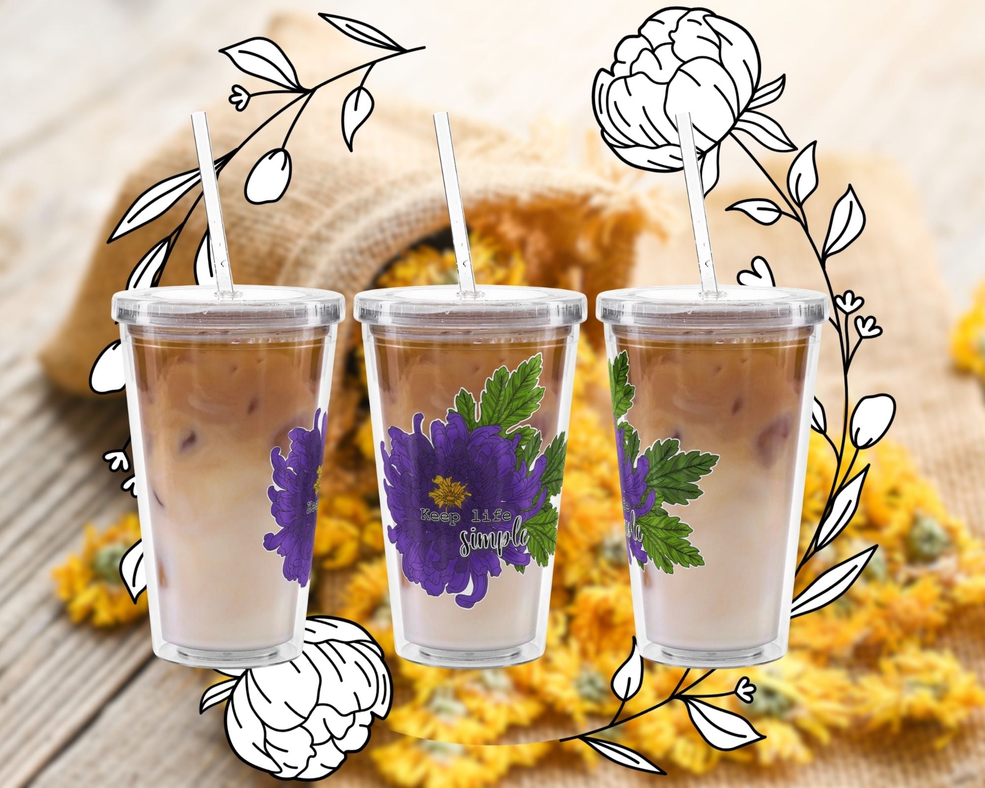 Three clear tumblers with purple floral designs on a wooden surface with flowers and leaves.