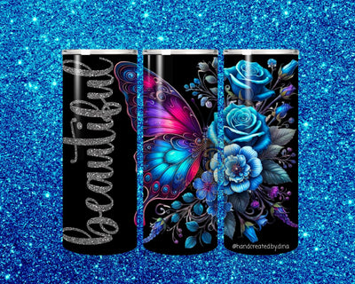 Three black tumblers with butterfly and floral designs on a blue glittery background
