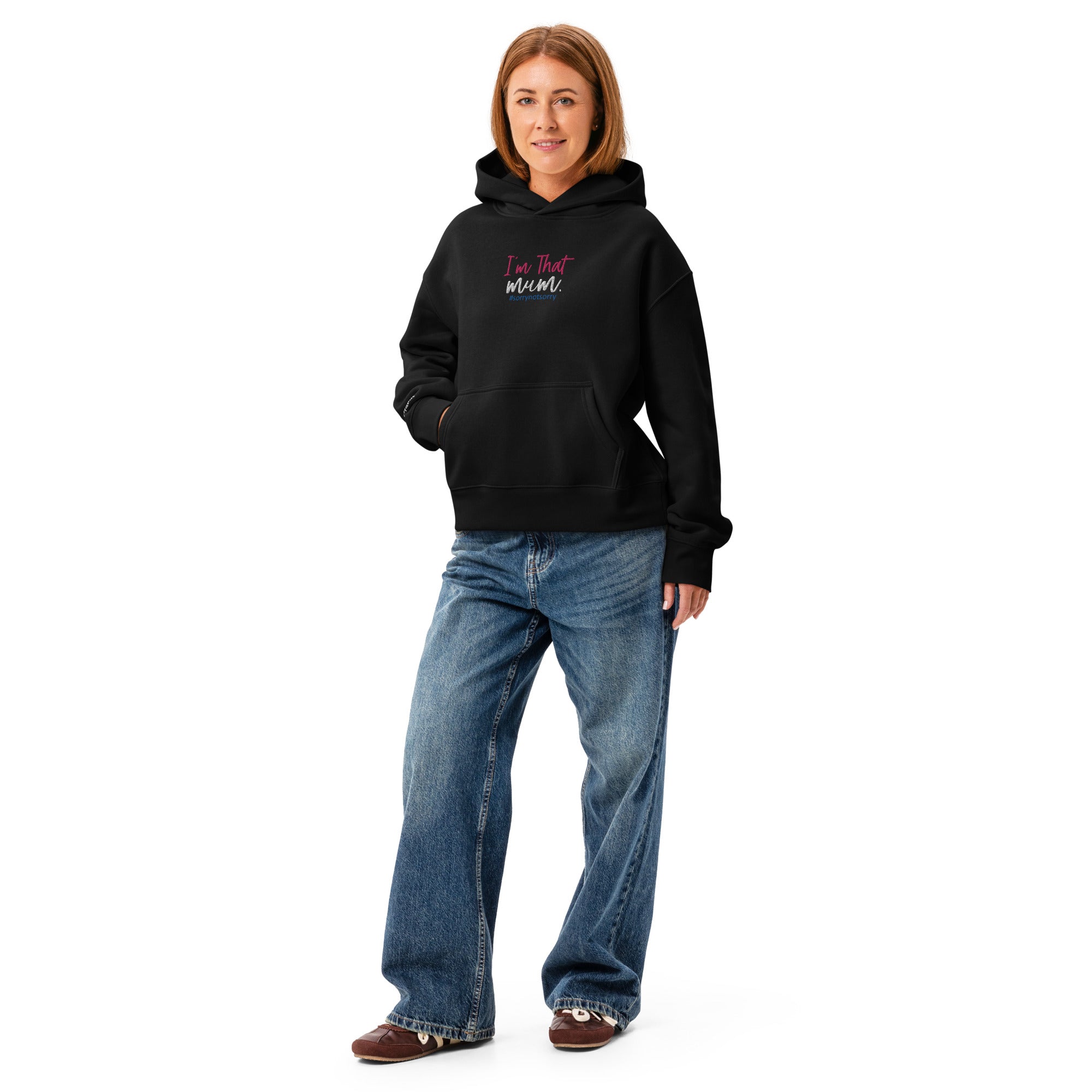 Person wearing a black hoodie with 'I'm That Mum' text and blue jeans on a white background