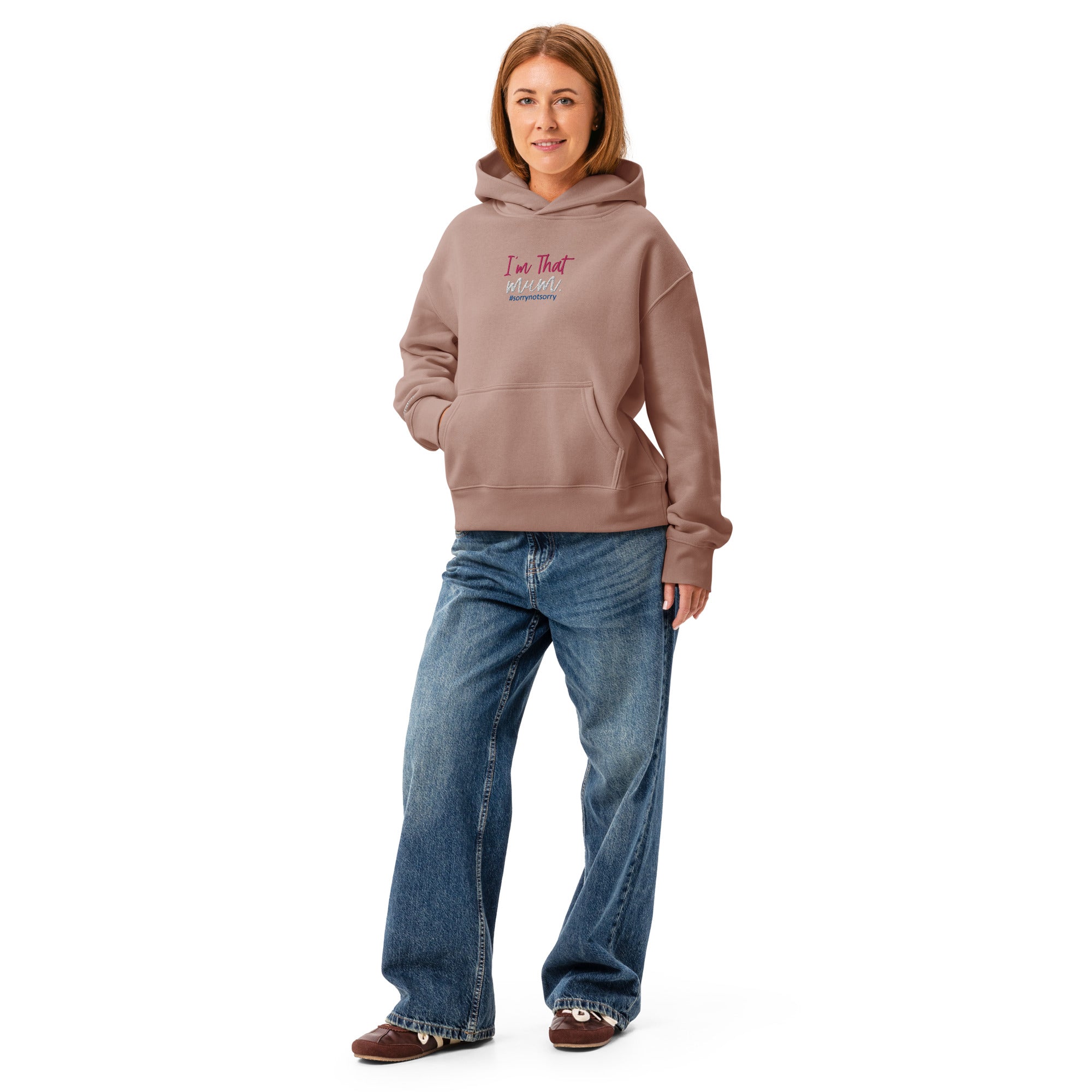 Person wearing a brown hoodie with text and blue jeans on a white background