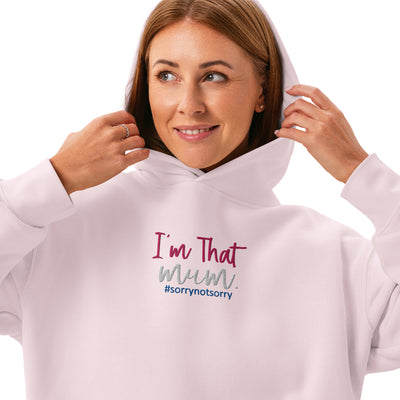 Woman wearing a light pink hoodie with text 'I'm That Mum sorrynotsorry' on a white background