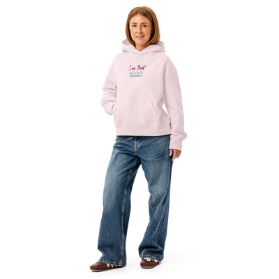 Person wearing a light pink hoodie with text and blue jeans on a white background