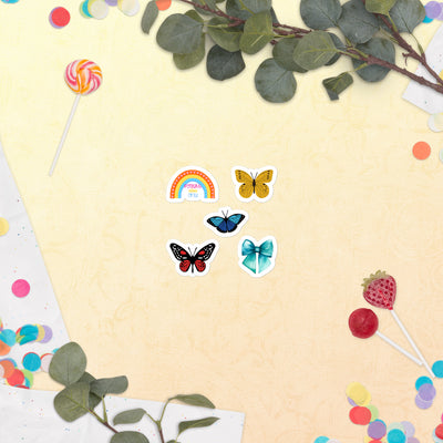 Colourful butterfly and rainbow stickers on a yellow background with leaves and lollipops.
