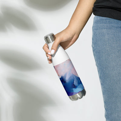 Person holding a water bottle with a mountain design on a light background
