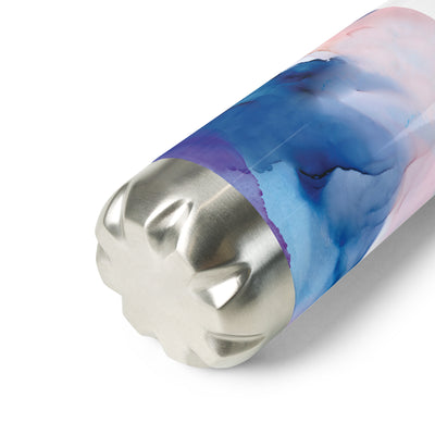 Marbled cylindrical bottle with a metallic base on a white background