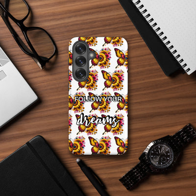 Phone case with floral and butterfly design on a wooden desk with accessories.