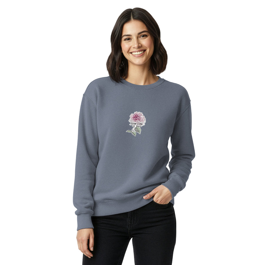 Woman wearing a gray sweatshirt with a floral design on a white background