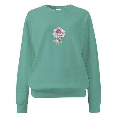 Teal sweatshirt with a floral design and text on a white background