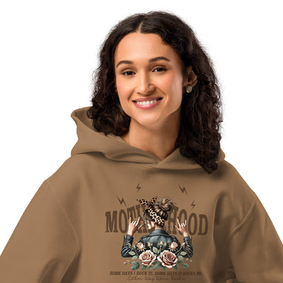 Person wearing a brown hoodie with a graphic design on a white background