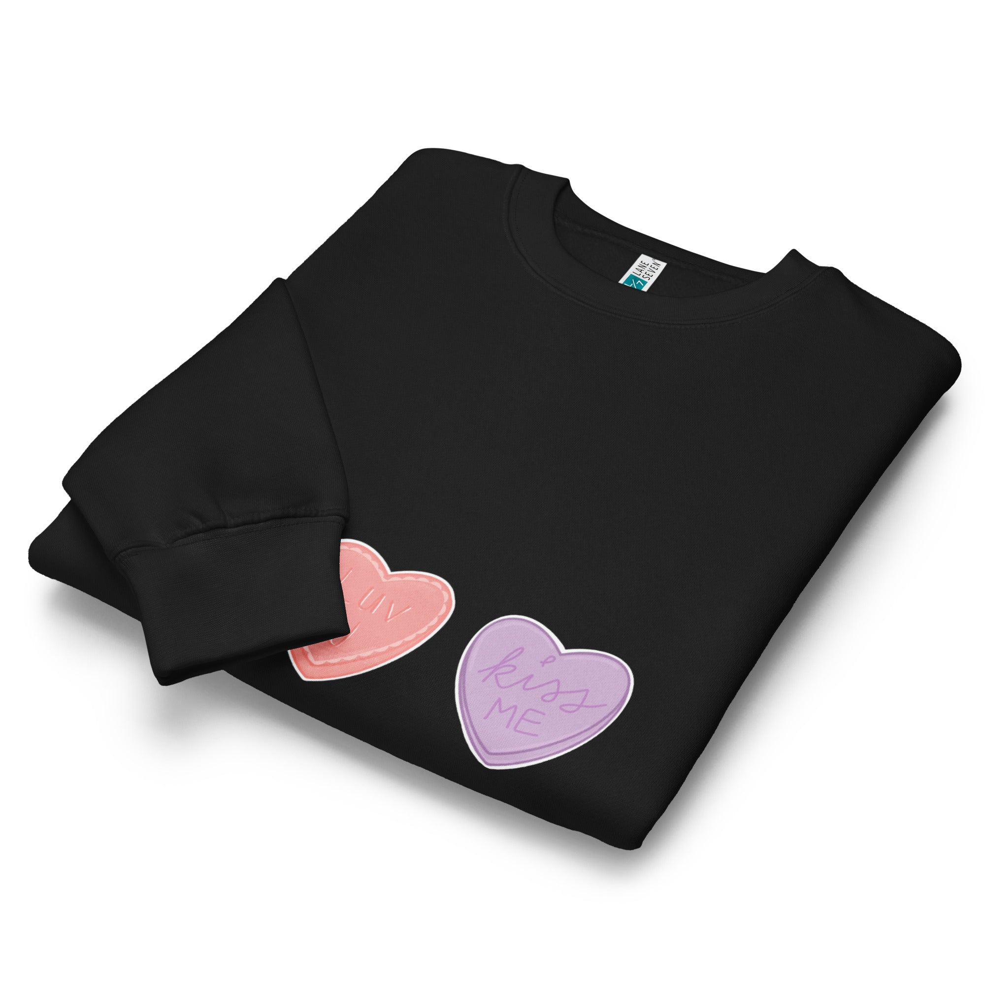 Folded black sweatshirt with pink and purple hearts on a white background