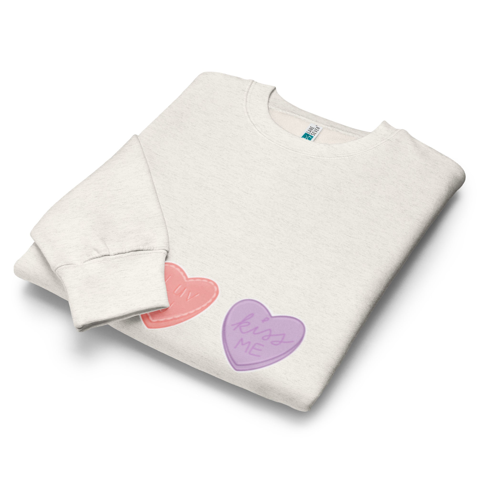 Folded grey sweatshirt with colourful heart designs on a white background