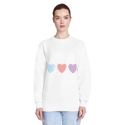 White sweatshirt with colourful heart designs worn by a woman on a white background