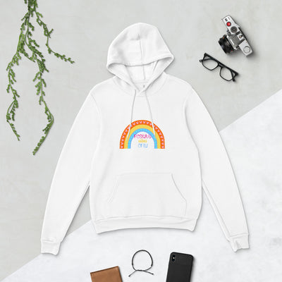 White hoodie with rainbow design on a light grey surface with accessories around