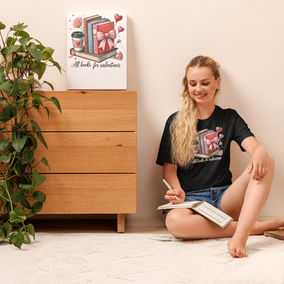 Woman sitting on the floor with a book, next to a wooden dresser and a plant.