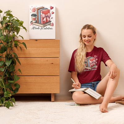 Woman sitting on the floor reading a book with a wooden dresser and plant in the background