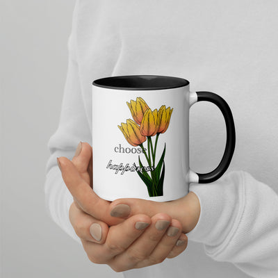 Mug with yellow tulips and 'choose happiness' text held by a person