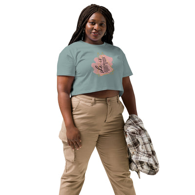 Woman wearing a green crop t-shirt with a motivational quote text design and beige pants on a white background