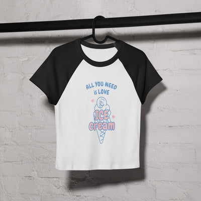 Black and white baseball shirt with ice cream graphic and text on a hanger against a textured wall.