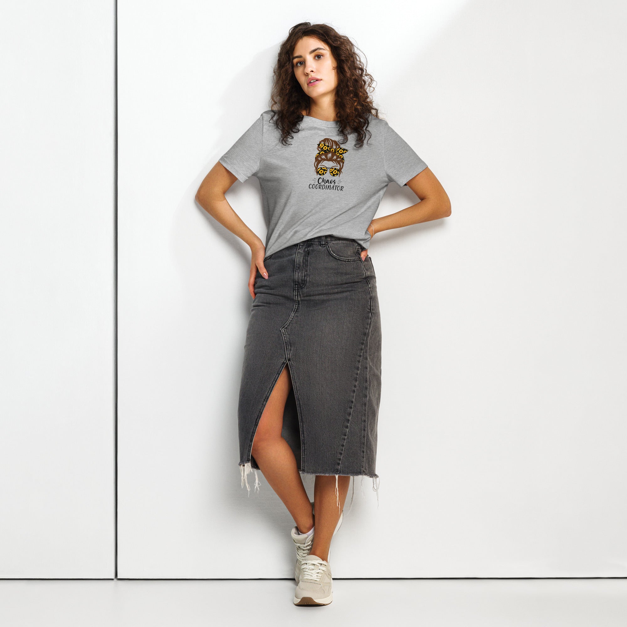 Woman wearing a grey t-shirt with a girl logo and a denim skirt on a white background