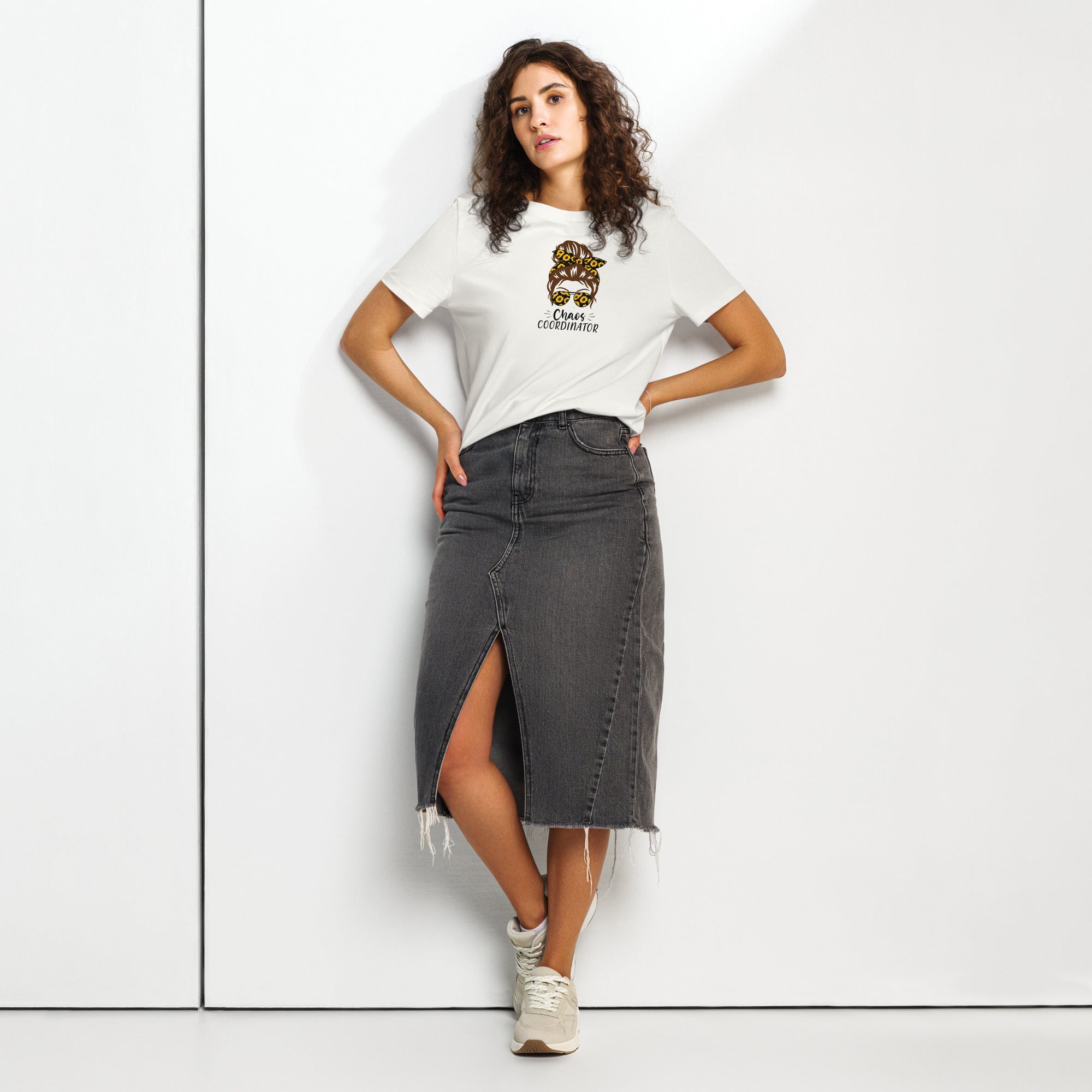 Woman wearing a white t-shirt with a logo and a black denim skirt on a white background