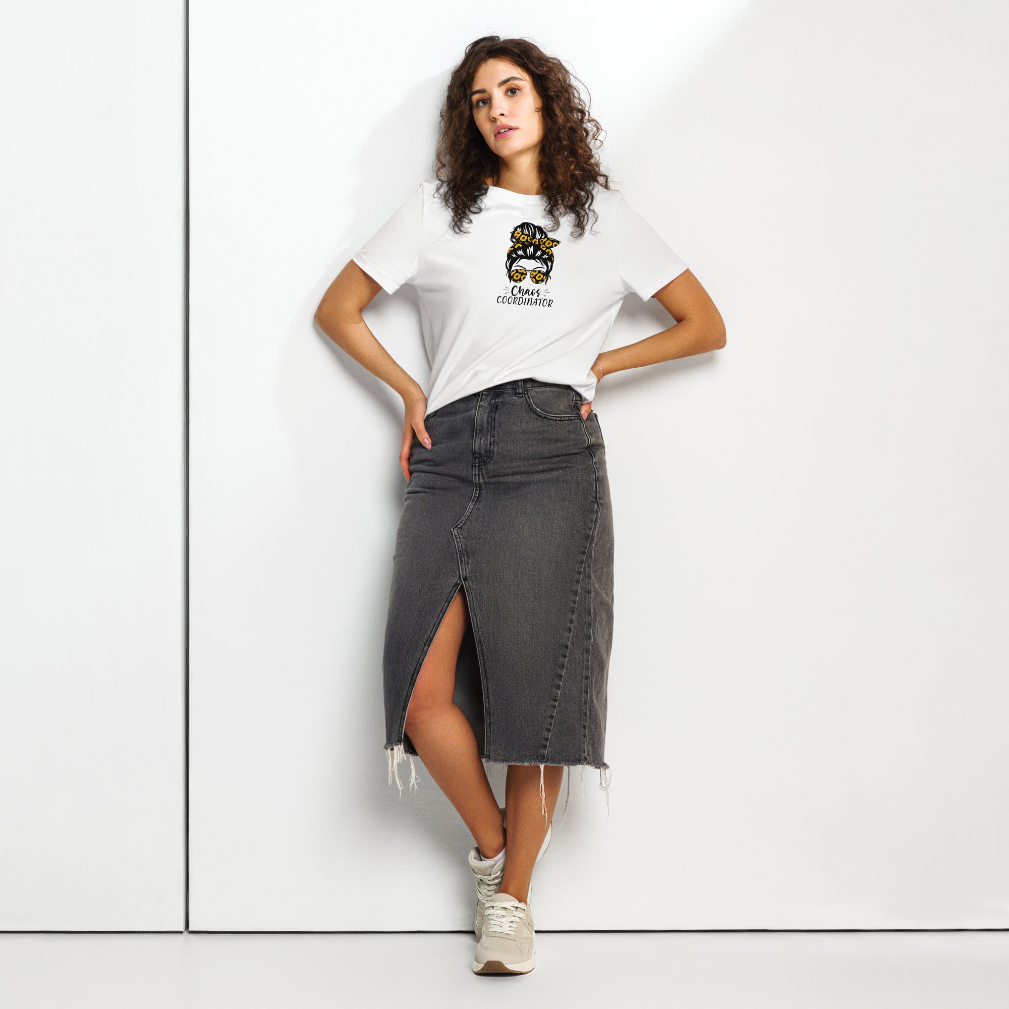 Woman wearing a white t-shirt with a graphic girl design and a black denim skirt on a white background