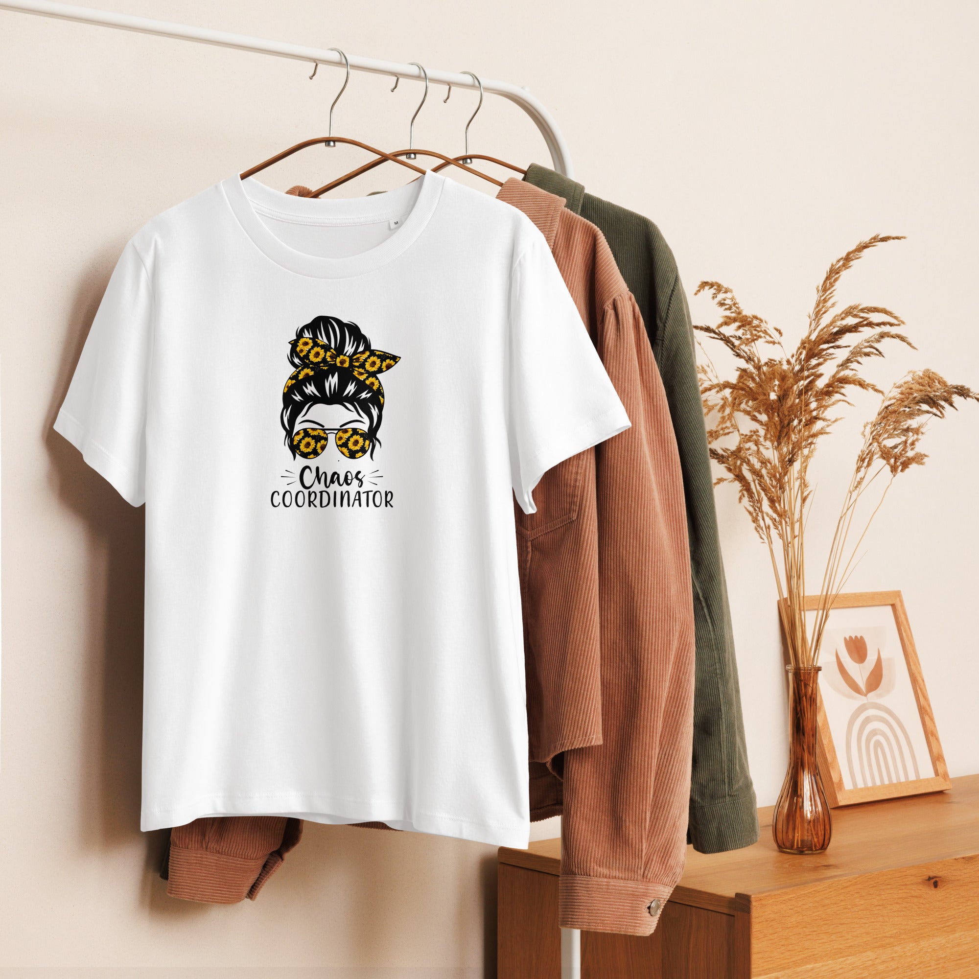 White t-shirt with graphic girl design hanging on a rack with other clothes.